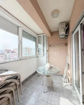 Enclosed balcony with a small glass table and chairs. - image 5