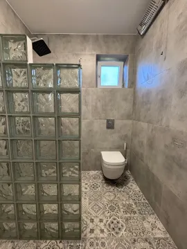 Moderne kupatilo sa tuš kabinom od staklenih blokova i sivim pločicama. - image 6