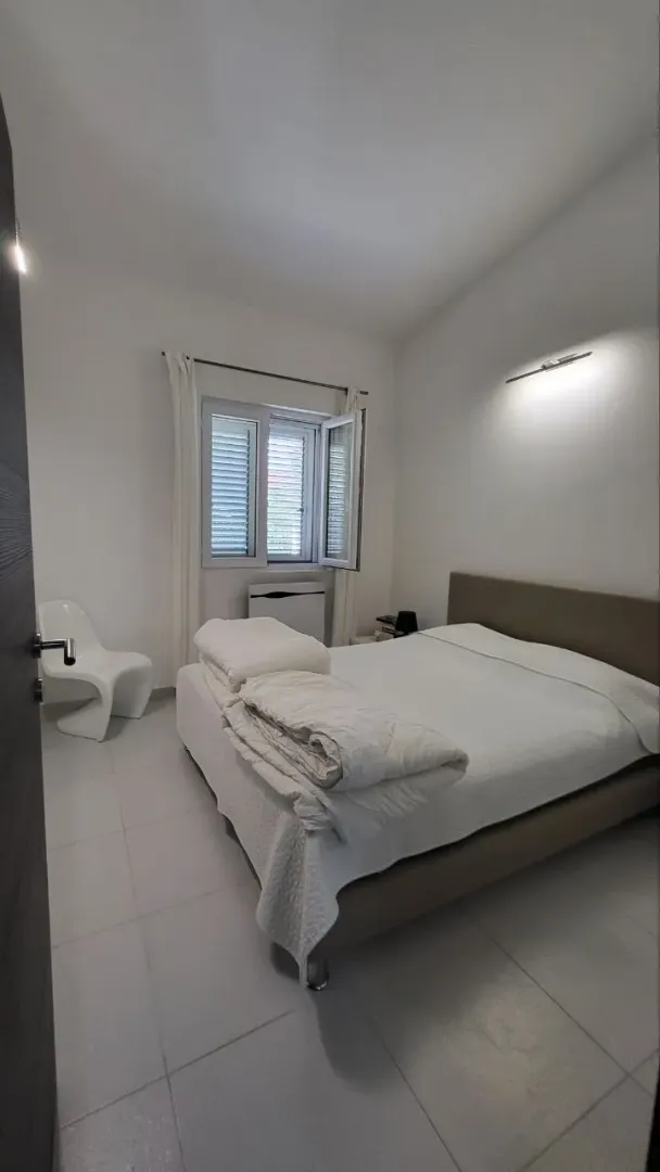 Svjetla i uredna spavaća soba sa bračnim krevetom.