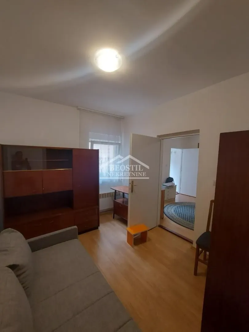 Dnevna soba sa garniturom, drvenim nameštajem i pogledom na unutrašnjost.