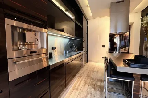 Modern kitchen with built-in appliances and a breakfast bar. - image 11