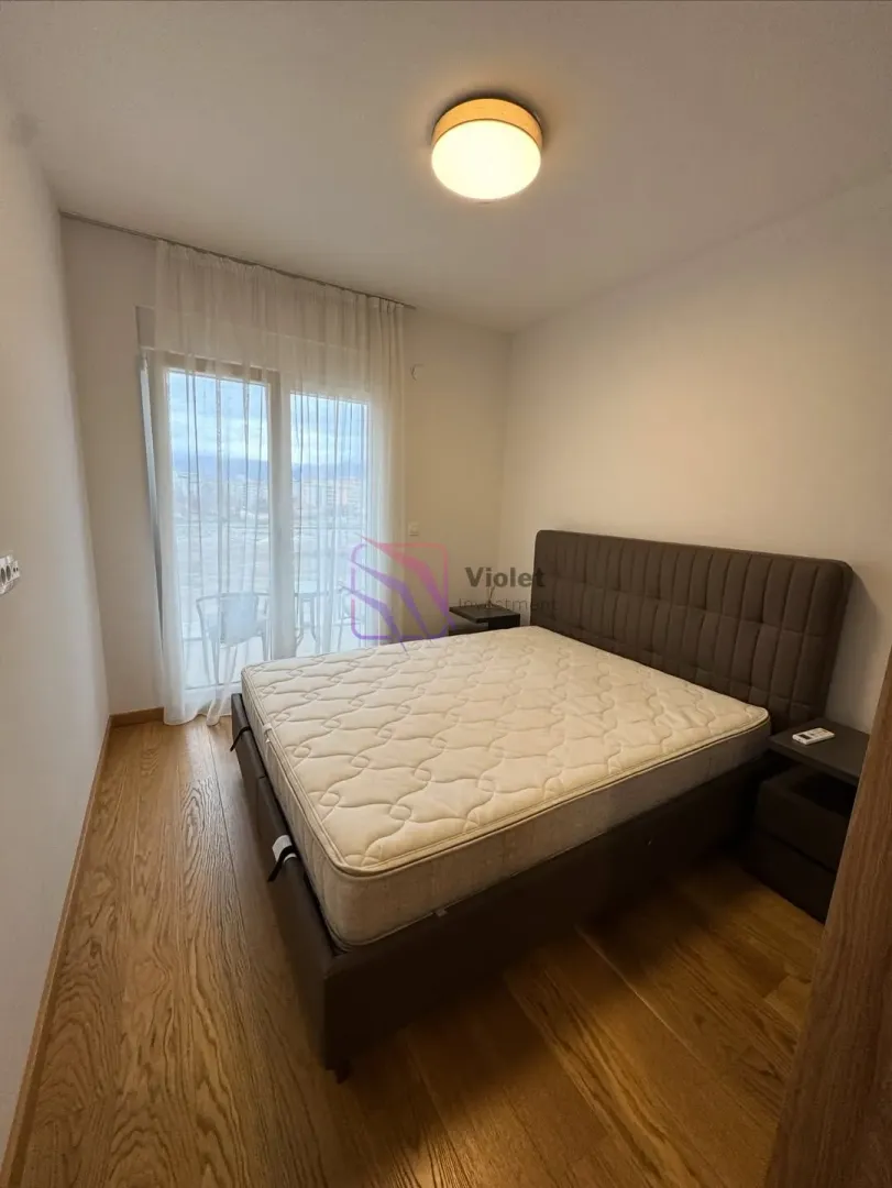 Spavaća soba sa bračnim krevetom i izlazom na terasu.