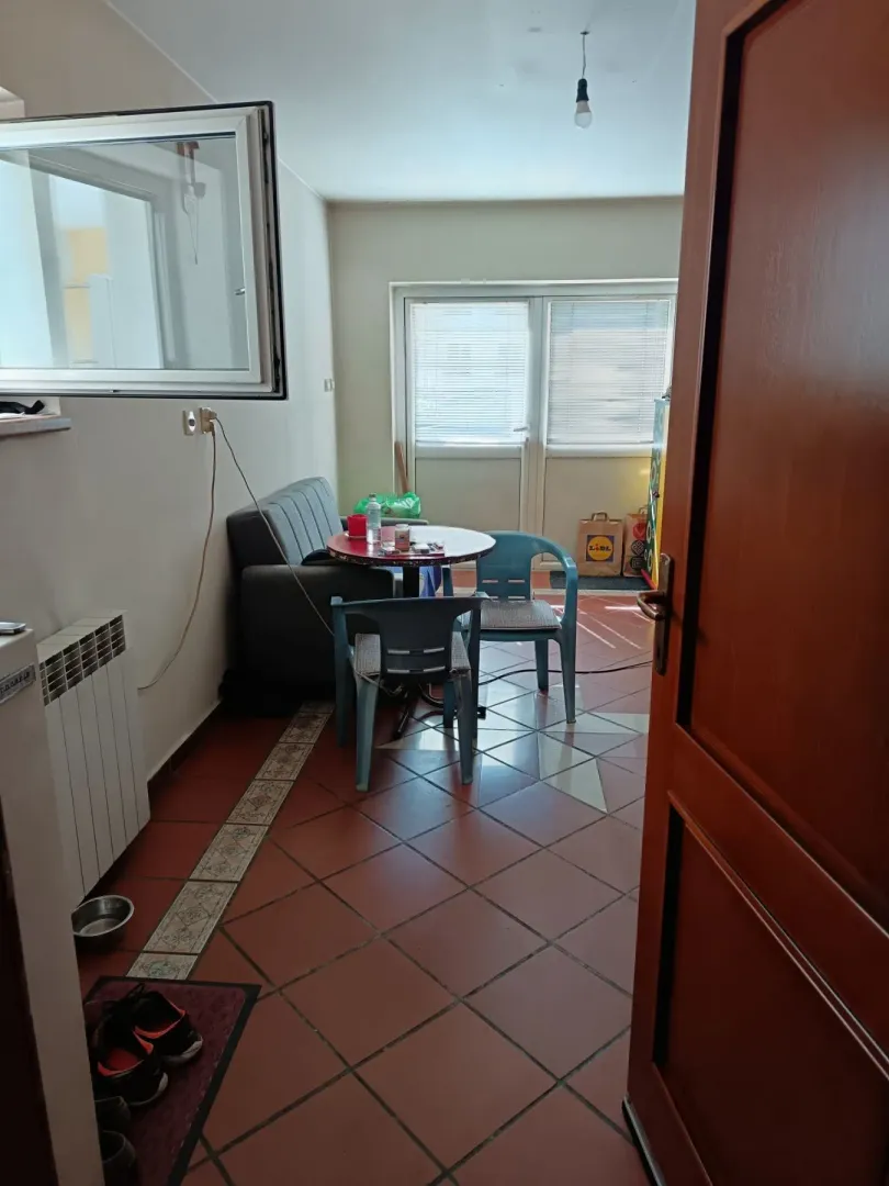Manji dnevni boravak sa garniturom, stolom i stolicama.