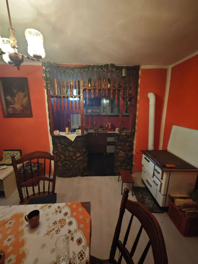 Trpezarija sa pogledom na kuhinju i peć na drva.