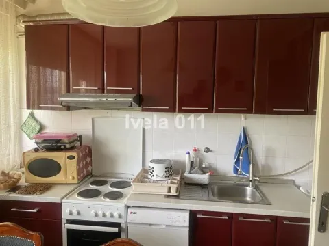 Manja kuhinja sa smeđim kuhinjskim elementima, šporetom i sudoperom. - image 2