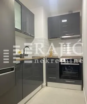 Modern kitchen with dark cabinets and built-in appliances. - image 16