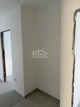 Prikaz dela enterijera sa belim zidovima i otvorima za vrata u fazi renoviranja. - image 3