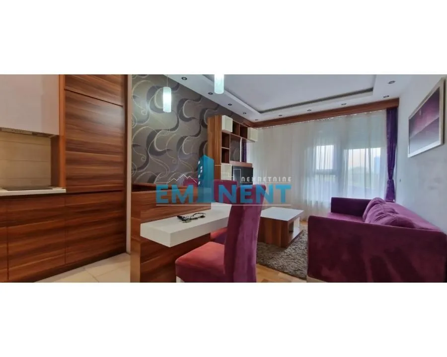Living room with a sofa set and dining area connected to the kitchen.