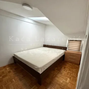 Attic bedroom with a double bed and a nightstand. - image 8