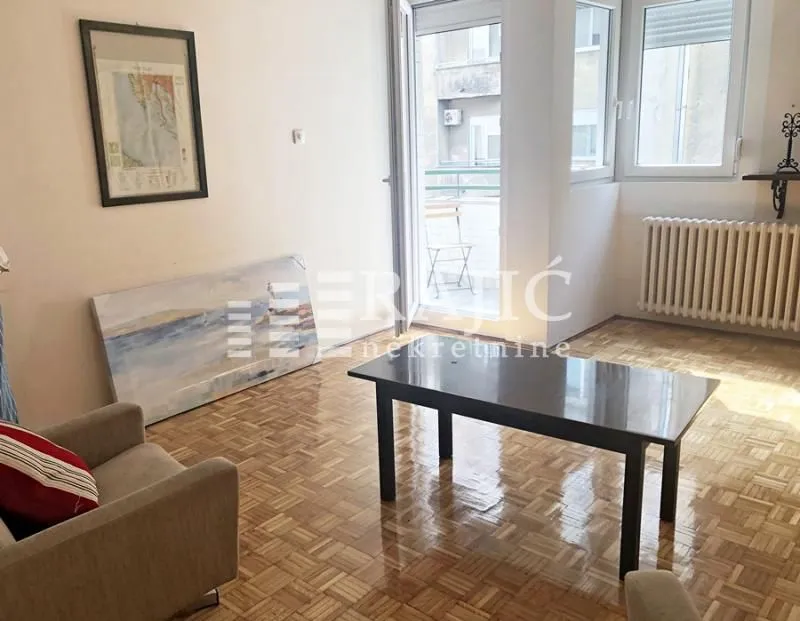 Living room with parquet flooring, a coffee table, and access to the terrace.