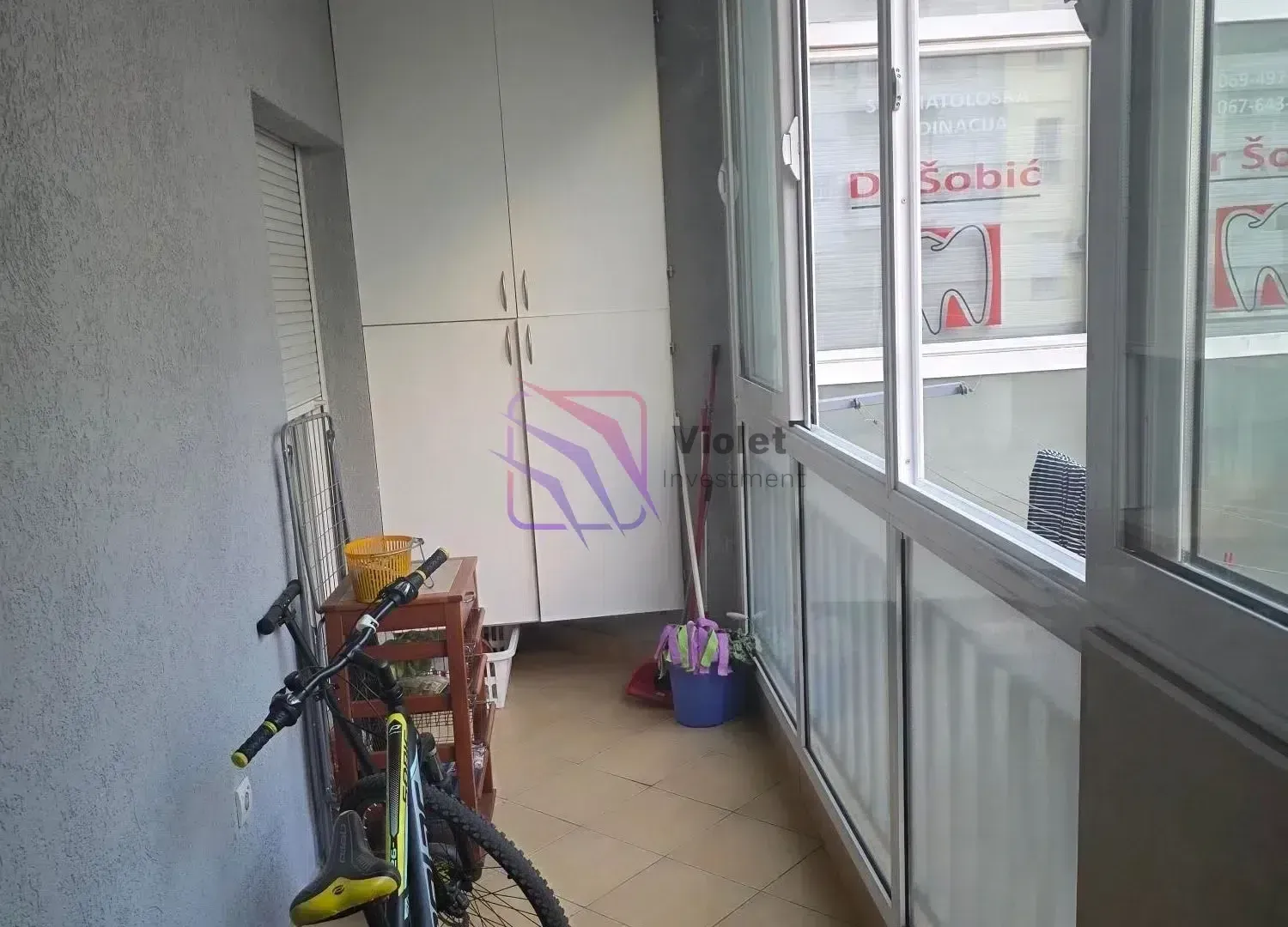 Zastakljena terasa sa ugradnim ormarom, policom i biciklom.