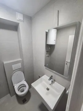 Moderno opremljeno kupatilo sa umivaonikom, WC šoljom i ogledalom. - image 9