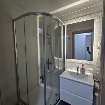 Bathroom equipped with a shower cabin and a washbasin. - image 7