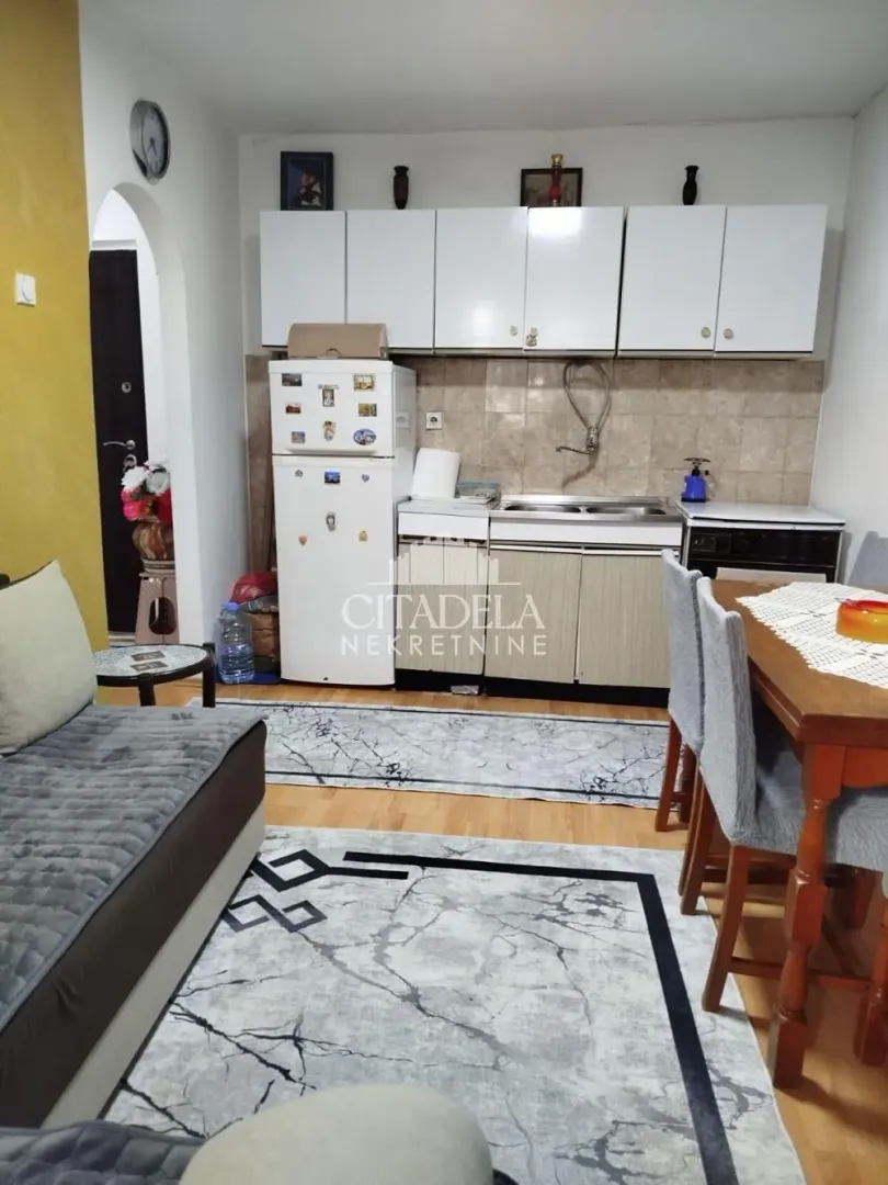 Small kitchen with a dining table and refrigerator integrated into the living area.
