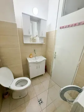 Kupatilo opremljeno umivaonikom, ormarićem sa ogledalom i toaletom. - image 6