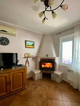 Living room with a fireplace, TV, and air conditioning. - image 6