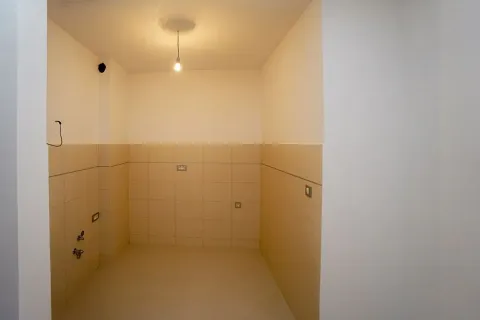 Prazna prostorija obložena pločicama sa instalacijama i sijalicom na plafonu. - image 5