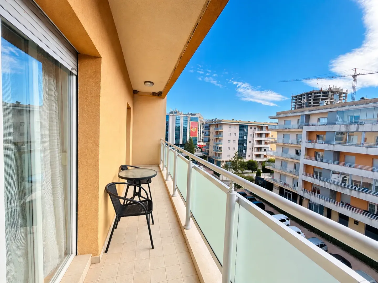 Natkriveni balkon sa garniturom za sjedenje i pogledom na grad.