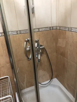 Shower cabin with glass doors and ceramic tiles in a bathroom. - image 5
