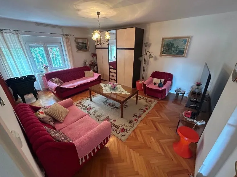Living room with seating furniture, wooden coffee table, and a television.