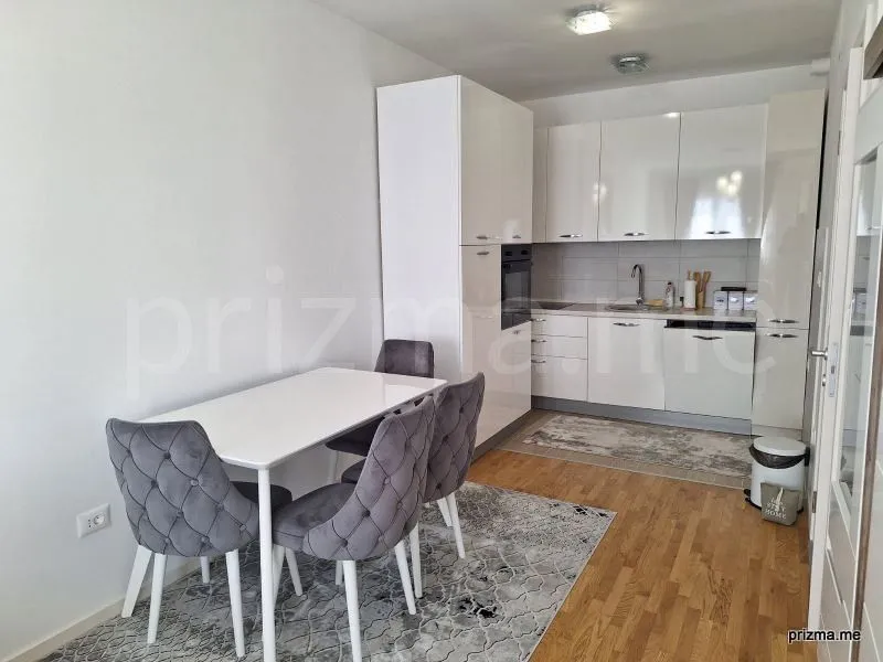 Modern kitchen with a dining area and white cabinetry.
