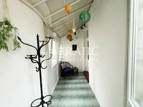 Enclosed terrace with a coat rack and decorative paper lanterns. - image 10