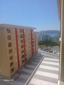 Pogled sa terase na susjednu zgradu i more u daljini. - image 5