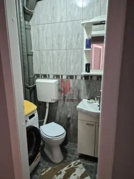 Small bathroom with a toilet, sink, mirror, and washing machine. - image 2