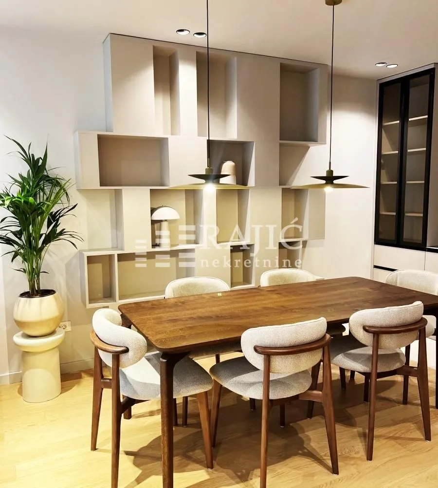 Modern dining room with a wooden table and chairs next to wall shelves.