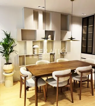 Modern dining room with a wooden table and chairs next to wall shelves. - image 2