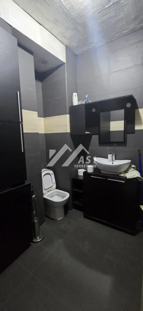 Bathroom equipped with dark furniture and sanitary ware.