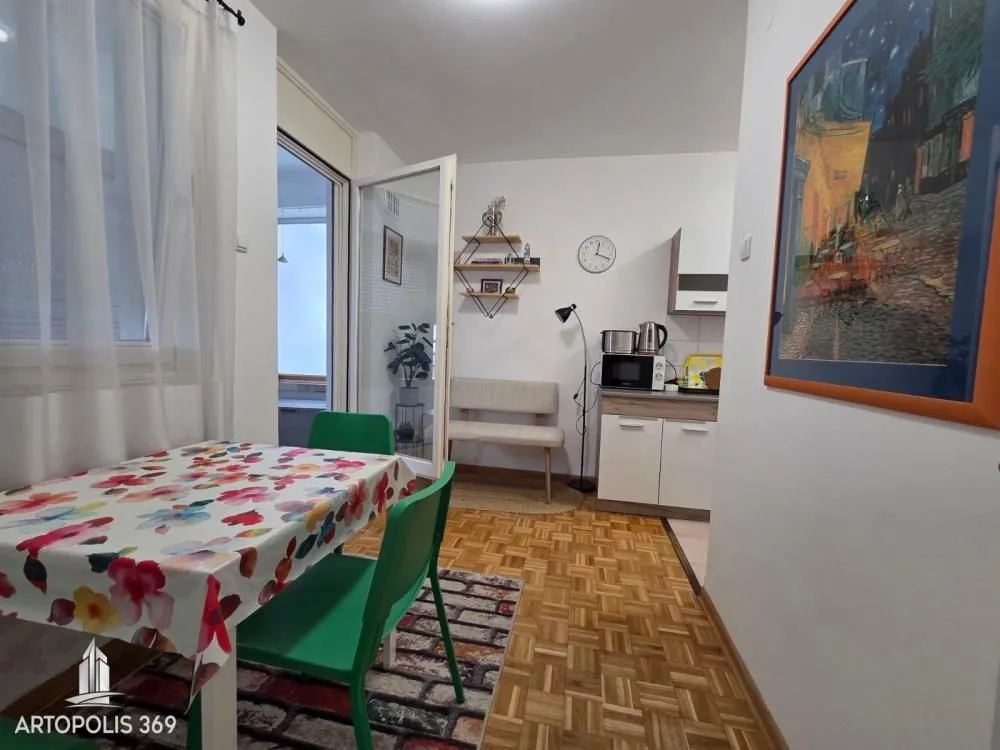 Manja kuhinja sa trpezarijskim stolom i izlazom na terasu.