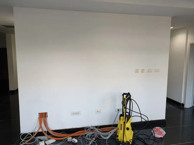 Interior of a room with white walls and equipment on the floor.