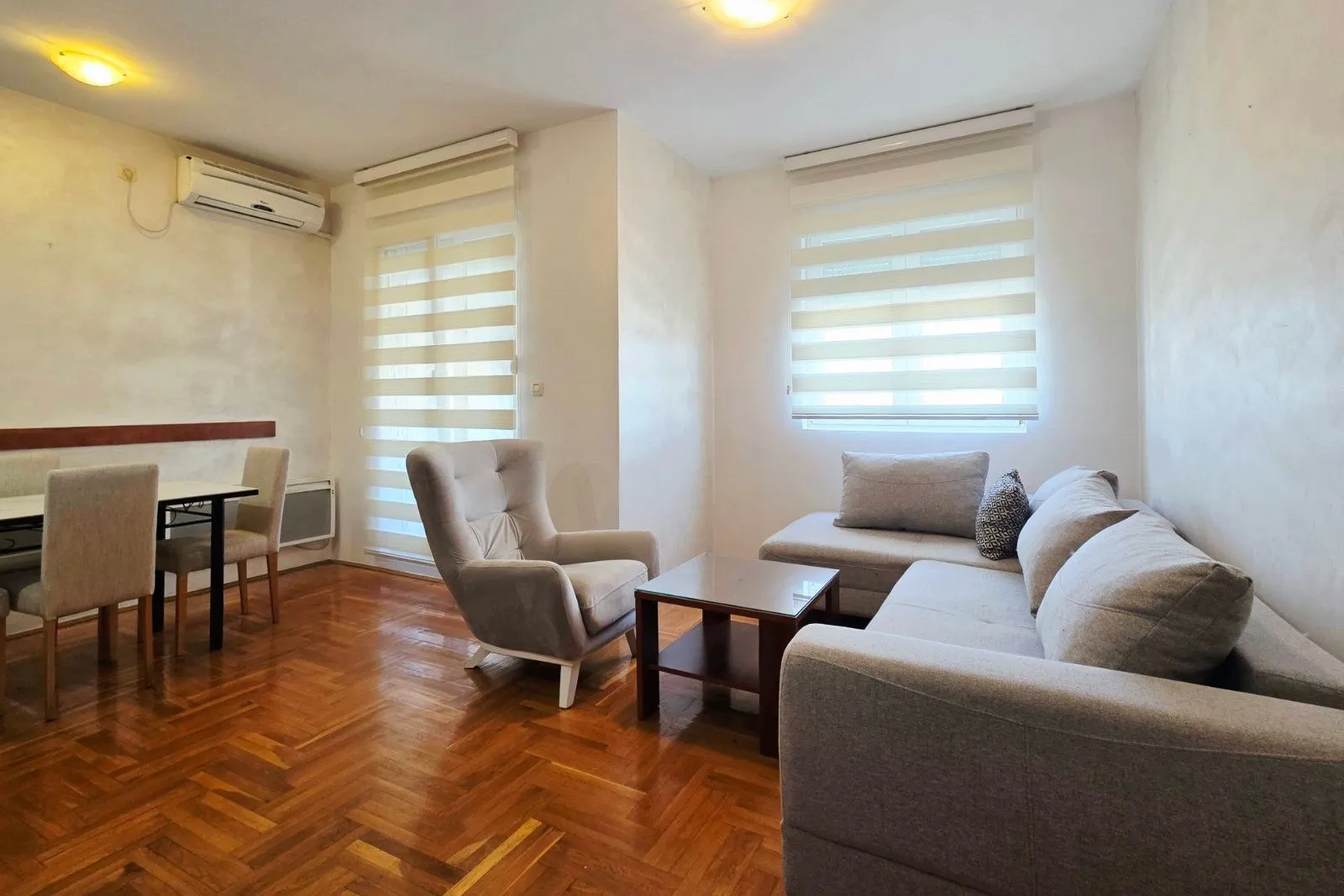 Spacious living room with a sofa set, armchair, and dining area.