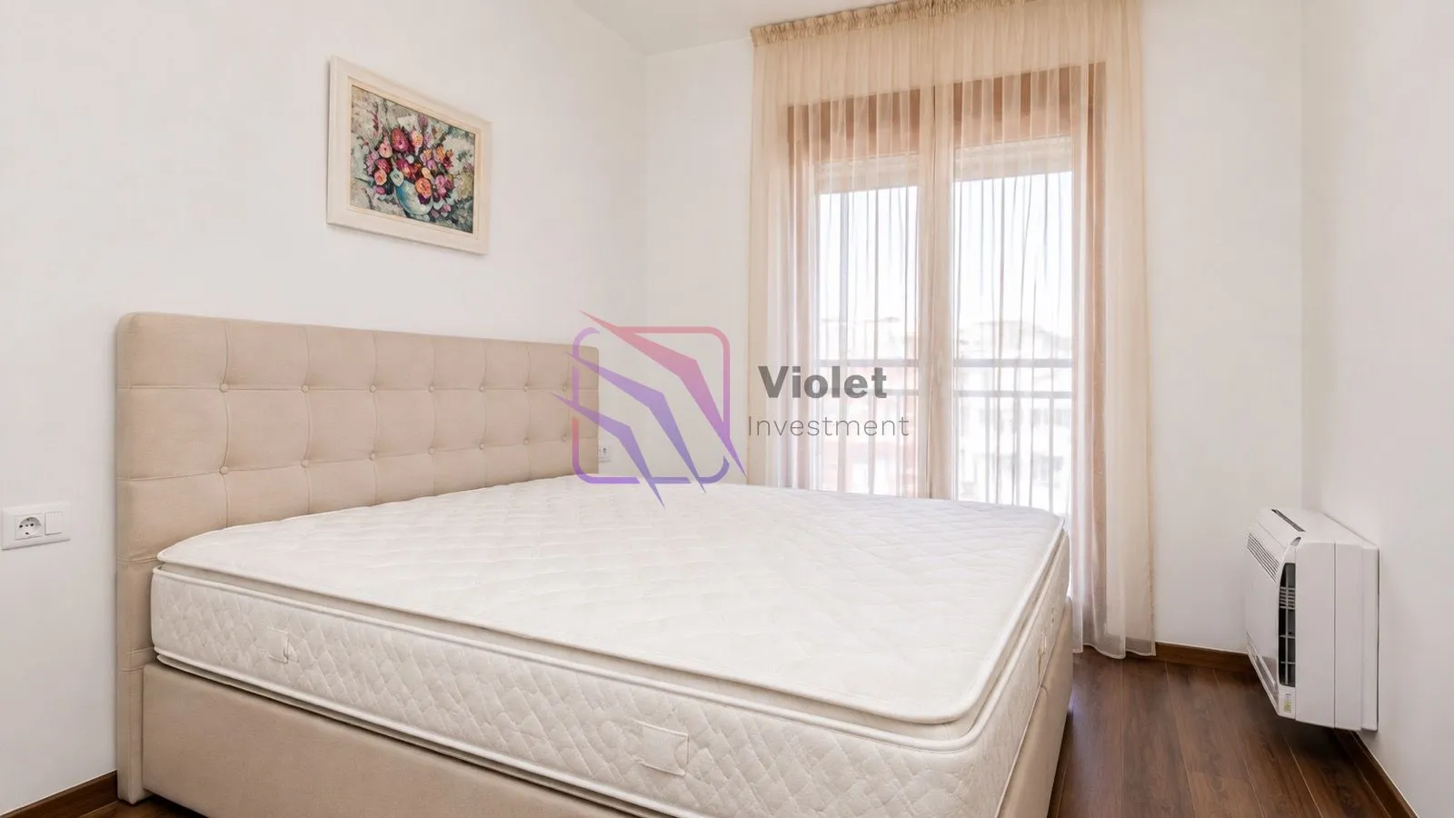 Bright bedroom with a double bed and a window with curtains.