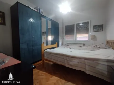 Nameštena spavaća soba sa bračnim krevetom i velikim plavim garderoberom. - image 9