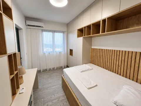 Furnished bedroom with built-in wardrobes and a wooden bed headboard. - image 10