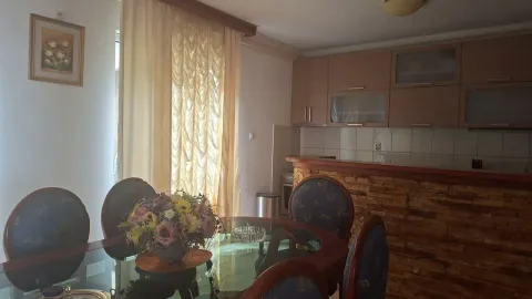 Trpezarija sa stolom i stolicama povezana sa kuhinjom. - image 4
