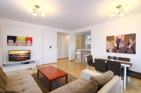 Spacious living room with a dining area and part of the kitchen in light tones. - image 15