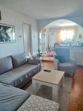 Dnevna soba sa garniturom, foteljom i stočićem, sa pogledom na trpezariju. - image 2