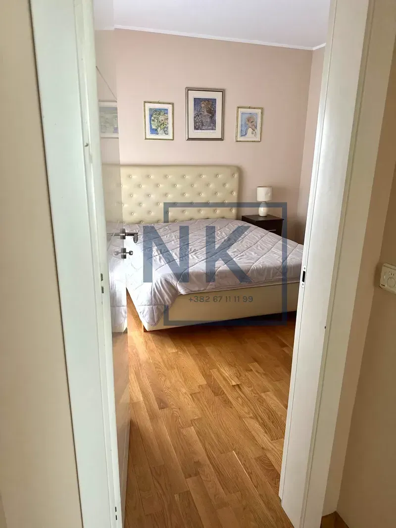View through an open door into a furnished bedroom with a double bed.