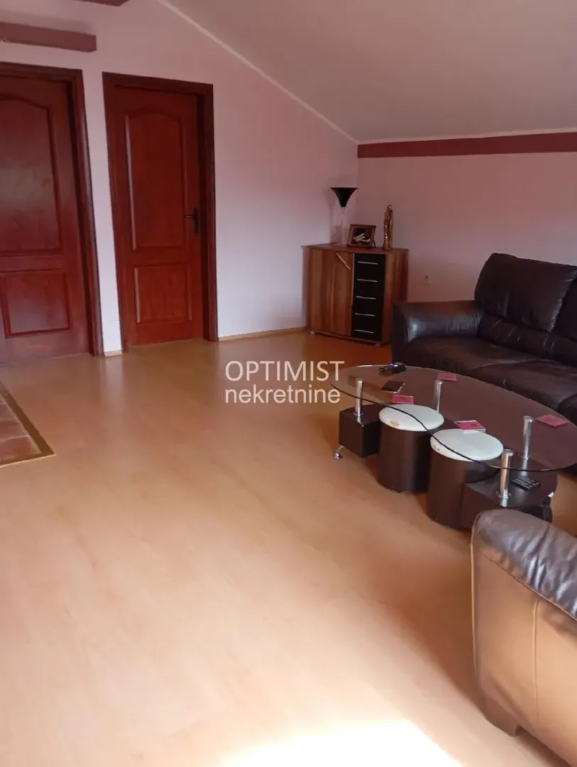 Living room with seating furniture and wooden flooring.