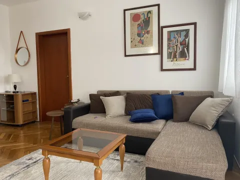 A bright living room featuring a comfortable sectional sofa, a wooden coffee table, and framed art on the wall. - image 2