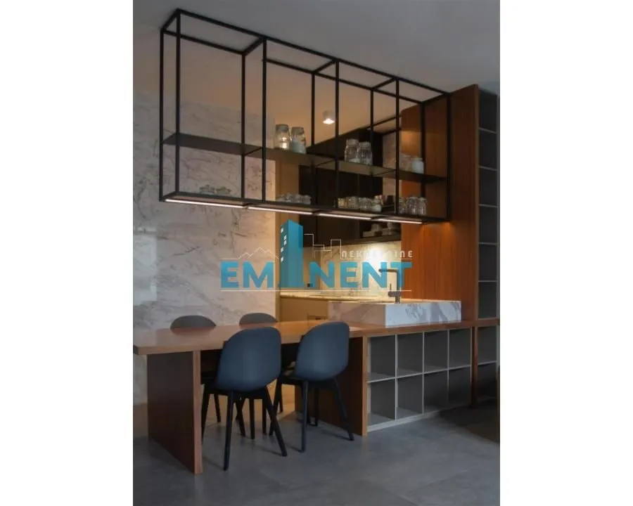 Modern kitchen with a dining table and a hanging black metal shelf.