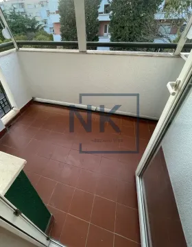 Smaller enclosed balcony with tiled flooring and a view of surrounding buildings. - image 11