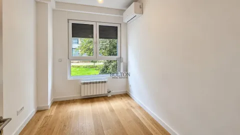 Prazna svetla soba sa drvenim podom, prozorom i klima uređajem. - image 8