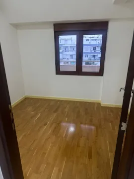 Prazna soba sa drvenim podom i prozorom koji gleda na susjedne zgrade. - image 7