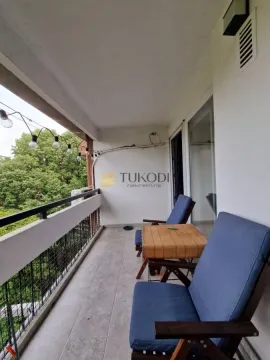 Covered balcony with seating furniture and a view of greenery. - image 17