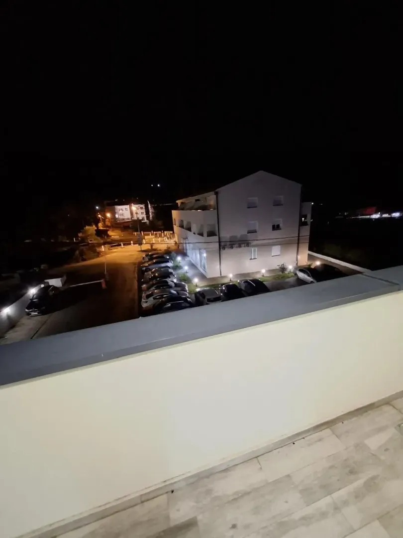 View from the terrace of the building and parking lot at night.
