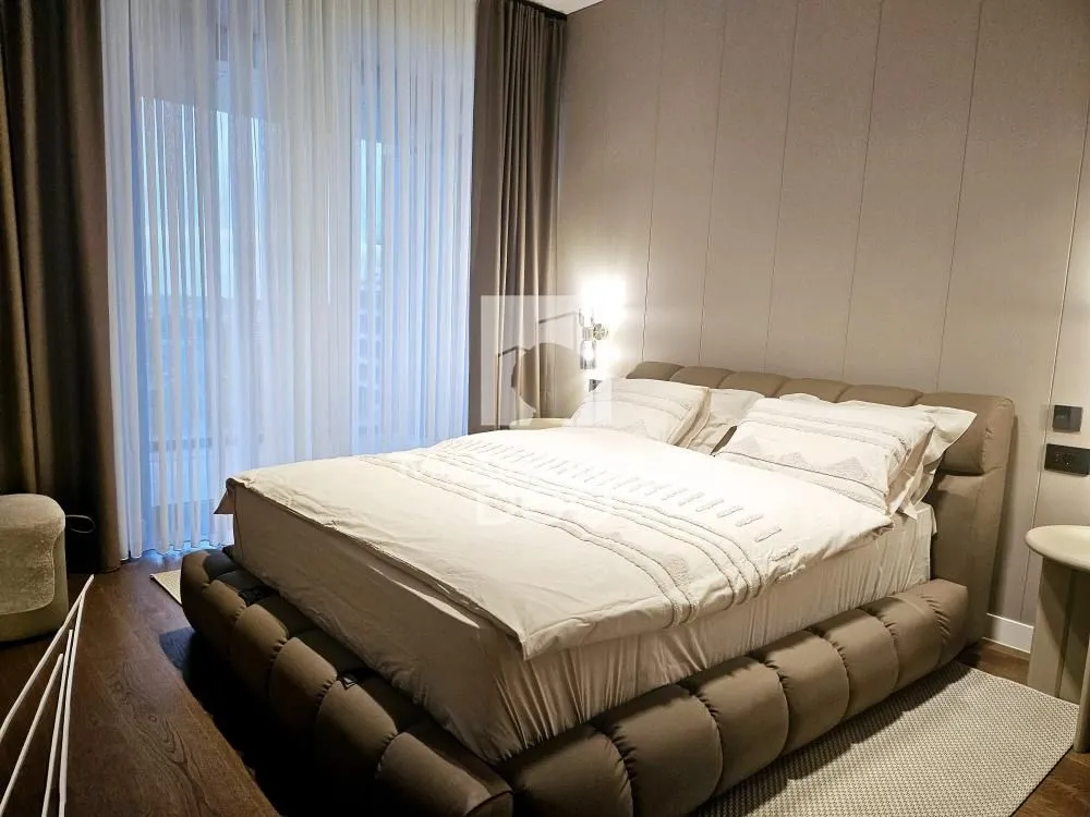 Modern bedroom with a large double bed and upholstered headboard.